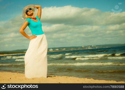 Fashion, happiness and lifestyle concept Beautiful girl in hat walking on beach. Young woman relaxing on the sea coast.