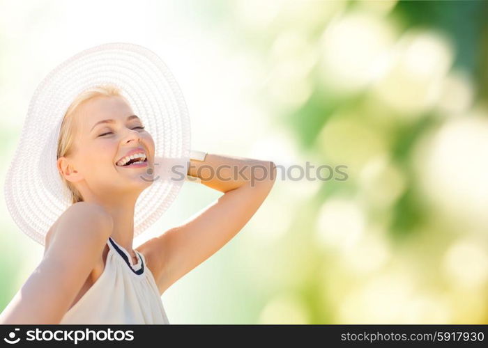 fashion, happiness and lifestyle concept - beautiful woman in hat enjoying summer outdoors