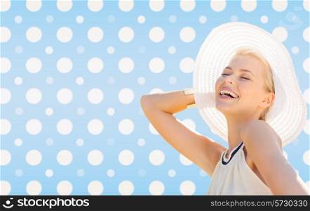 fashion, happiness and people concept - beautiful smiling woman in white summer hat over blue and white polka dots pattern background