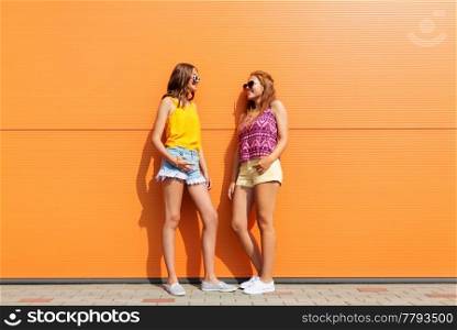 fashion, leisure and people concept - smiling teenage girls in summer clothes outdoors. smiling teenage girls in summer clothes outdoors
