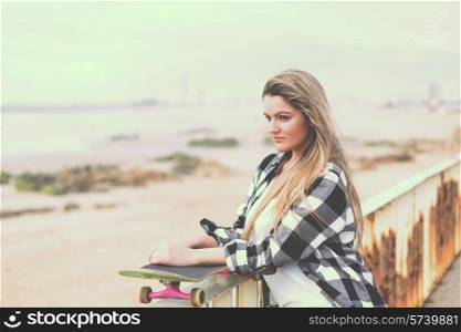 Fashion lifestyle, Beautiful young woman with skateboard - retro effect filter