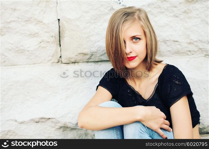 Fashion lifestyle portrait of young happy pretty blonde woman with red lips, bob hair laughing and having fun on the street at nice sunny day, wearing stylish vintage outfit, bright fresh colors.