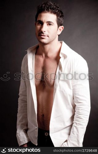Fashion male model standing over a black background
