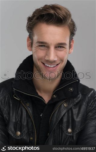 Fashion man, Handsome serious beauty male model portrait wear leather jacket, young guy over gray background