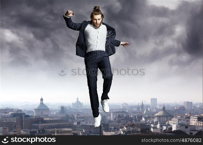 Fashion man jumping directly to the sky