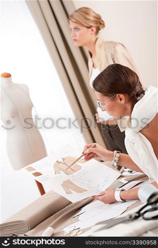 Fashion model fitting clothes by professional designer studio