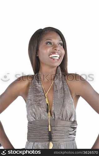 Fashion model in grey halter neck stands with hands on hips laughing