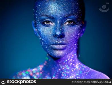 Fashion model woman in blue bright sparkles and neon lights posing in studio. Portrait of beautiful sexy woman. Art design colorful glitter glowing make up