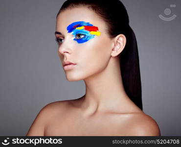 Fashion model woman with colored face painted. Beauty fashion art portrait of beautiful woman with colorful abstract makeup. Face painted paints. Multicolor design