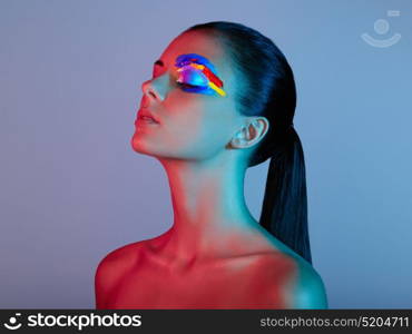 Fashion model woman with colored face painted. Beauty fashion art portrait of beautiful woman with colorful abstract makeup. Face painted paints. Multicolor design