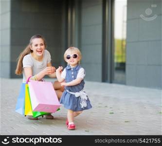 Fashion-monger baby on shopping with mom wear new glasses