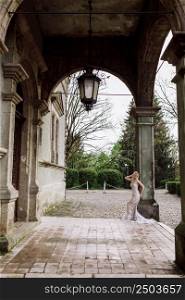 fashion outdoor photo of gorgeous young bride with blond hair in elegant long wedding dress posing near old castle.. fashion outdoor photo of gorgeous young bride with blond hair in elegant long wedding dress posing near old castle