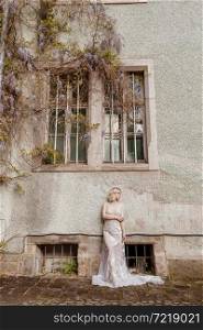 fashion outdoor photo of gorgeous young bride with blond hair in elegant long wedding dress posing near old castle. woman&rsquo;s day. selective focus. fashion outdoor photo of gorgeous young bride with blond hair in elegant long wedding dress posing near old castle. woman&rsquo;s day. selective focus.