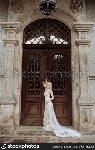 fashion outdoor photo of gorgeous young bride with blond hair in elegant long wedding dress posing near old castle.. fashion outdoor photo of gorgeous young bride with blond hair in elegant long wedding dress posing near old castle