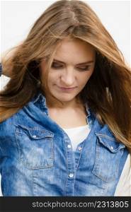 Fashion, people concept. Young lady is looking down. Girl is wearing denim jacket. . Young lady is looking down.
