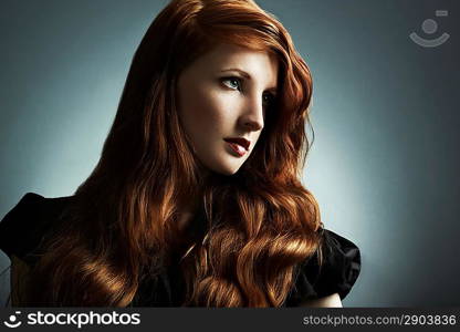 Fashion photo of a beautiful young red-haired woman. Close-up portrait