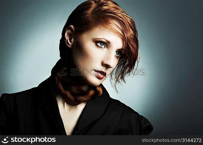 Fashion photo of a beautiful young red-haired woman. Close-up portrait