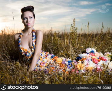 Fashion photo of beautiful lady in dress of flowers. Beautiful woman pose outdors.