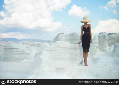 Fashion photo of beautiful lady in hat in an unusual landscape