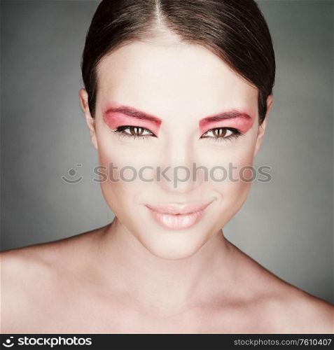 Fashion photo of beautiful lady with bright make-up. Modern art makeup with pink lipstick. Sexy woman pose in photography studio.
