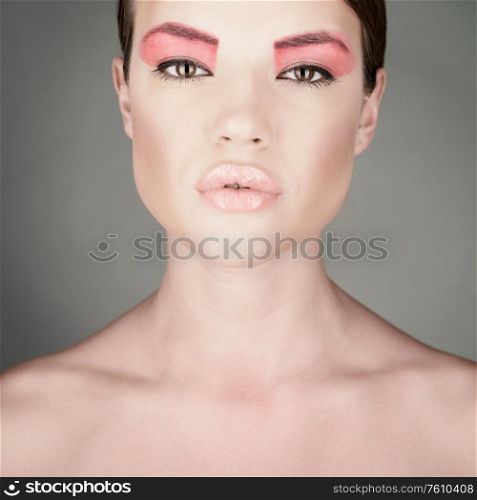Fashion photo of beautiful lady with bright make-up. Modern art makeup with pink lipstick. Sexy woman pose in photography studio.
