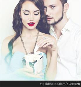 Fashion photo of beautiful romantic couple with gift