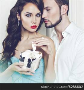 Fashion photo of beautiful romantic couple with gift