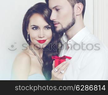 Fashion photo of beautiful romantic couple with gift