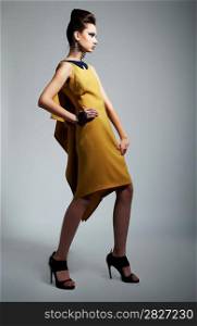 Fashion photo of beautiful stylish woman in yellow trendy dress. Studio shot