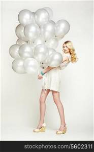 Fashion photo of beautiful woman with balloons. Girl posing. Studio photo