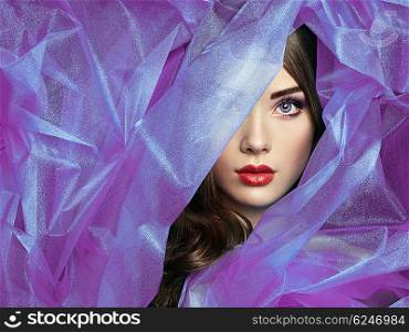 Fashion photo of beautiful women under purple veil. Beauty portrait. Perfect makeup. Eyelashes. Lips. Cosmetic Eyeshadow