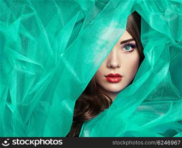 Fashion photo of beautiful women under turquoise veil. Beauty portrait. Perfect makeup. Eyelashes. Lips. Cosmetic Eyeshadow