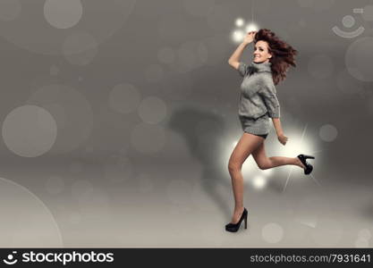 Fashion photo of running brunette woman over sparkling grey background