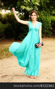 fashion photo of sexy glamour model in elegant turquoise dress posing outdoors
