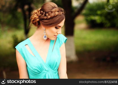 fashion photo of sexy glamour model in elegant turquoise dress posing outdoors