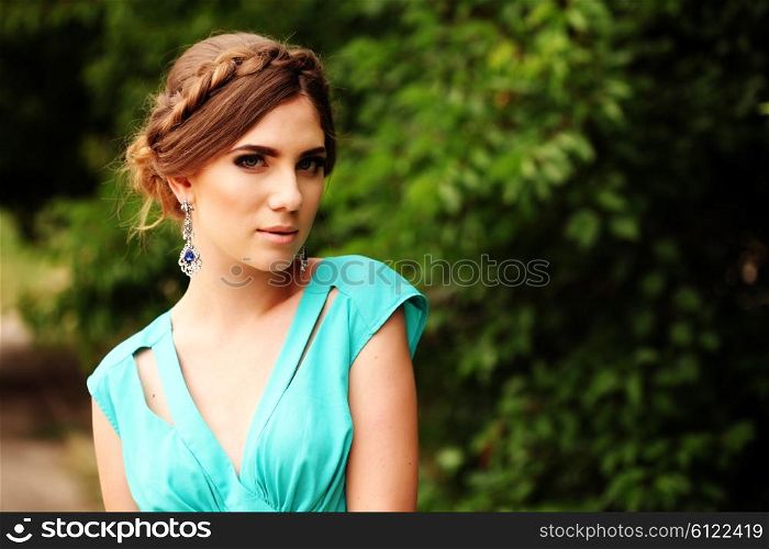 fashion photo of sexy glamour model in elegant turquoise dress posing outdoors