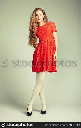 Fashion photo of young magnificent woman in red dress. Studio photo