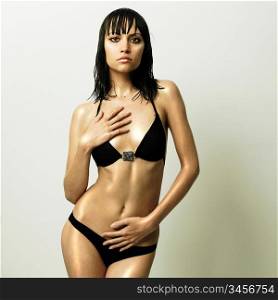 Fashion photo of young slender woman in fashionable swimsuit