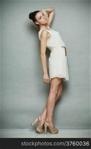 Fashion photo of young woman in full length. Girl posing. Studio shot gray background
