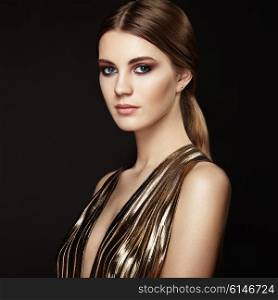 Fashion portrain of young beautiful woman in gold dress. Brunette glamour lady with perfect make up and hairstyle