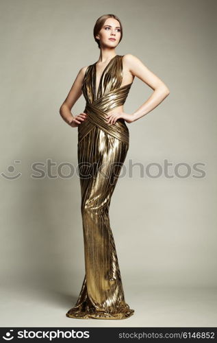 Fashion portrain of young beautiful woman in gold dress. Brunette glamour lady with perfect make up and hairstyle