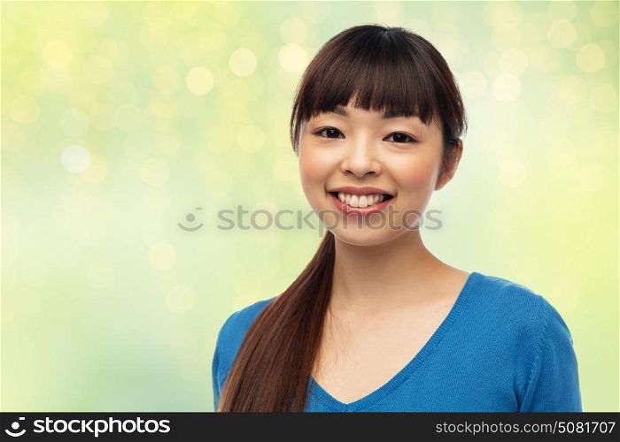 fashion, portrait and people concept - happy smiling young asian woman over green background with lights. happy smiling young asian woman