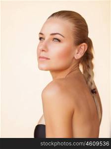 Fashion portrait of a beautiful blond girl with bare makeup over beige background, natural beauty of a woman face with a healthy skin, sensual look