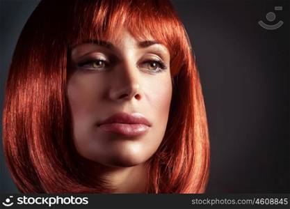 Fashion portrait of a beautiful woman with red hairstyle and perfect makeup, close up on gorgeous face over dark background, hairdresser and beauty salon