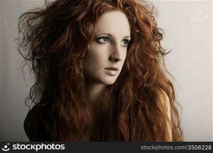 Fashion portrait of a young beautiful redheaded woman