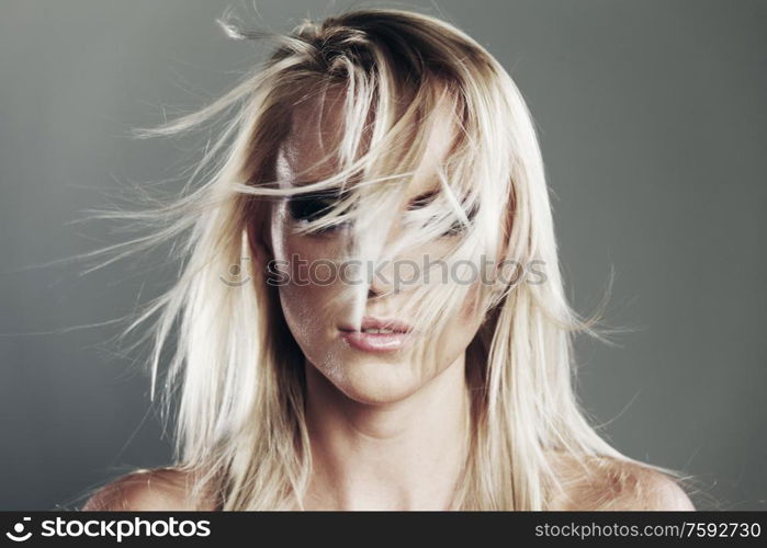 Fashion portrait of a young blonde woman on a gray background. Fashion woman portrait