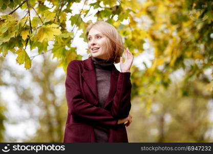 Fashion portrait of beautiful blonde woman in stylish clothes in autumn park.. Fashion portrait of beautiful blonde woman in stylish clothes in autumn park