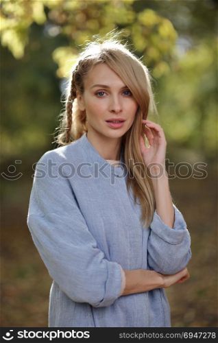 Fashion portrait of beautiful blonde woman in stylish clothes in autumn park.. Fashion portrait of beautiful blonde woman in stylish clothes in autumn park