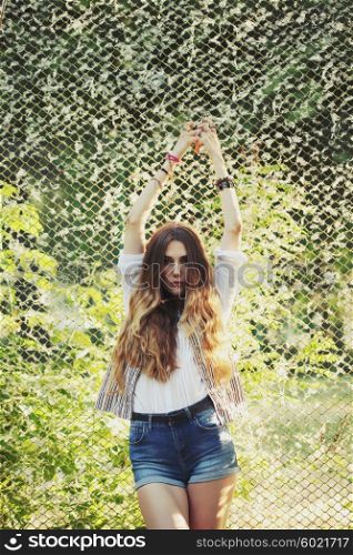 Fashion portrait of beautiful hippie young woman wearing boho chic clothes outdoors. Soft warm vintage color tone. Artsy bohemian style.