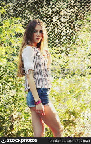 Fashion portrait of beautiful hippie young woman wearing boho chic clothes outdoors. Soft warm vintage color tone. Artsy bohemian style.